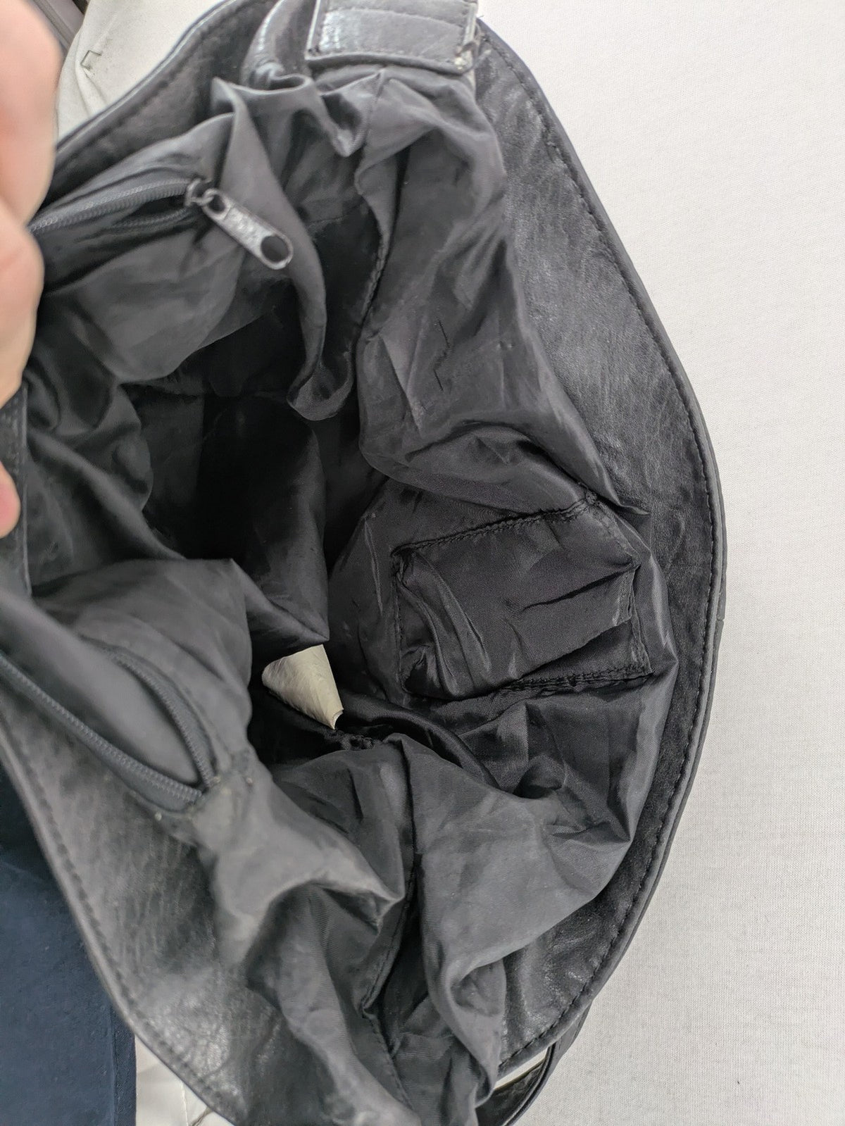 New Yorker black hobo handbag with silver chain details and large eyelets.