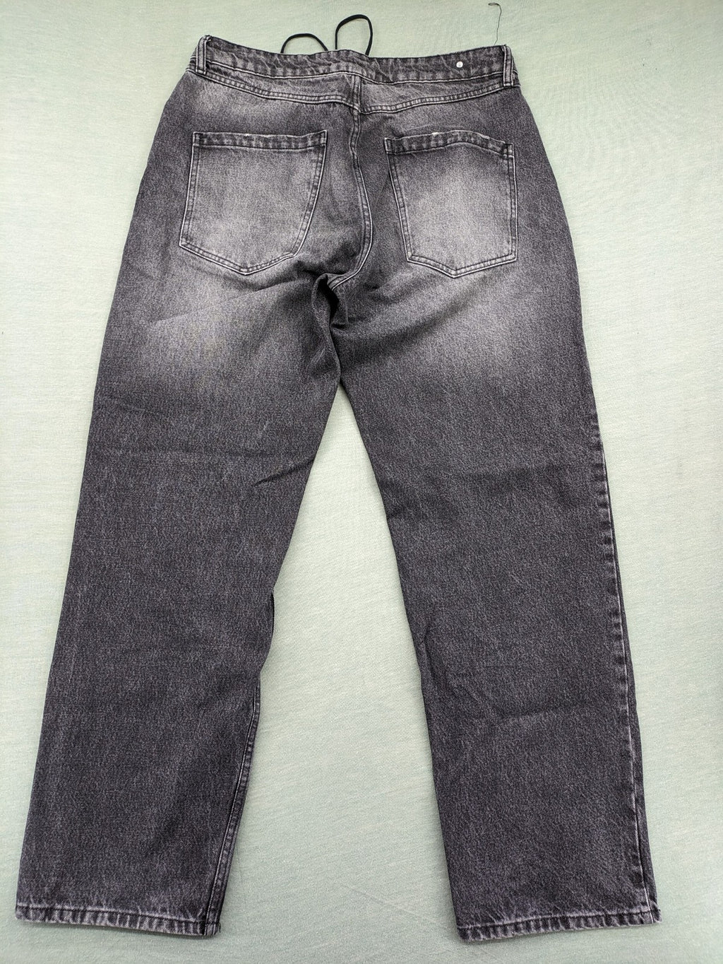Black Squad black straight jeans with Gothic "Paranoid" lettering and faded finish.