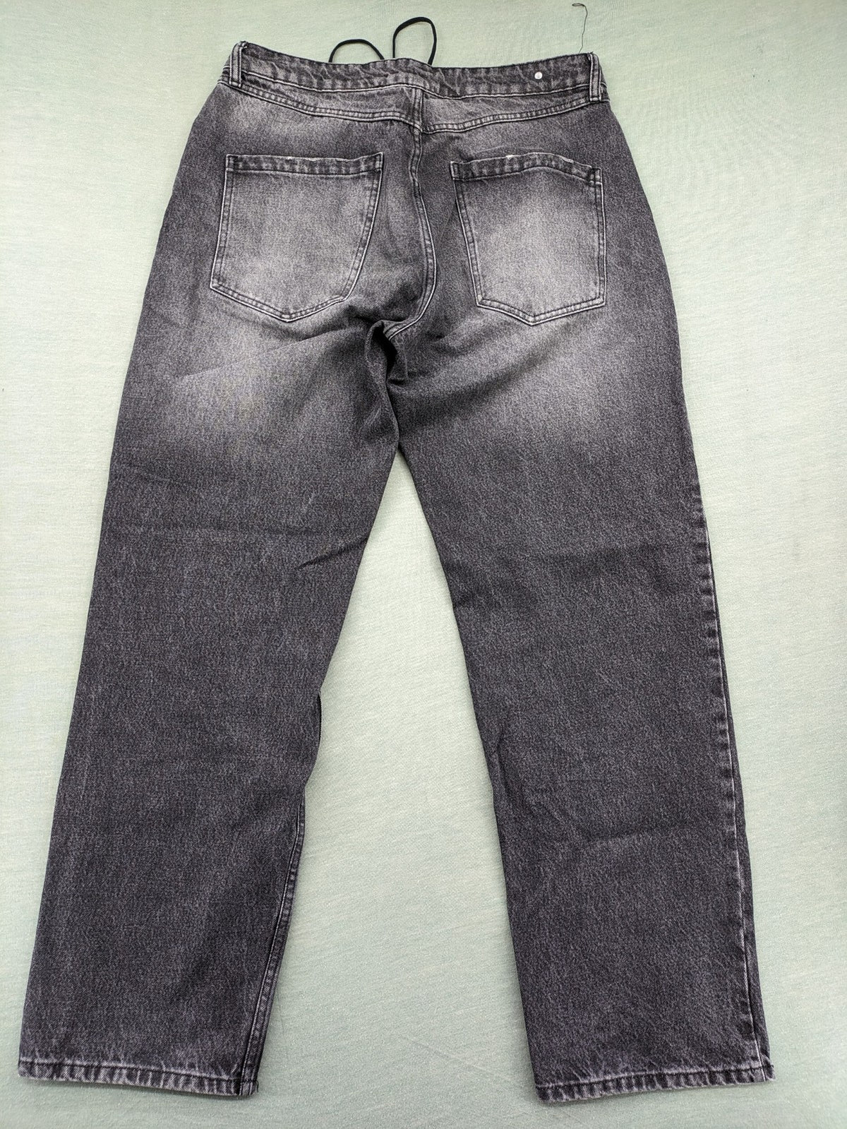 Black Squad black straight jeans with Gothic "Paranoid" lettering and faded finish.