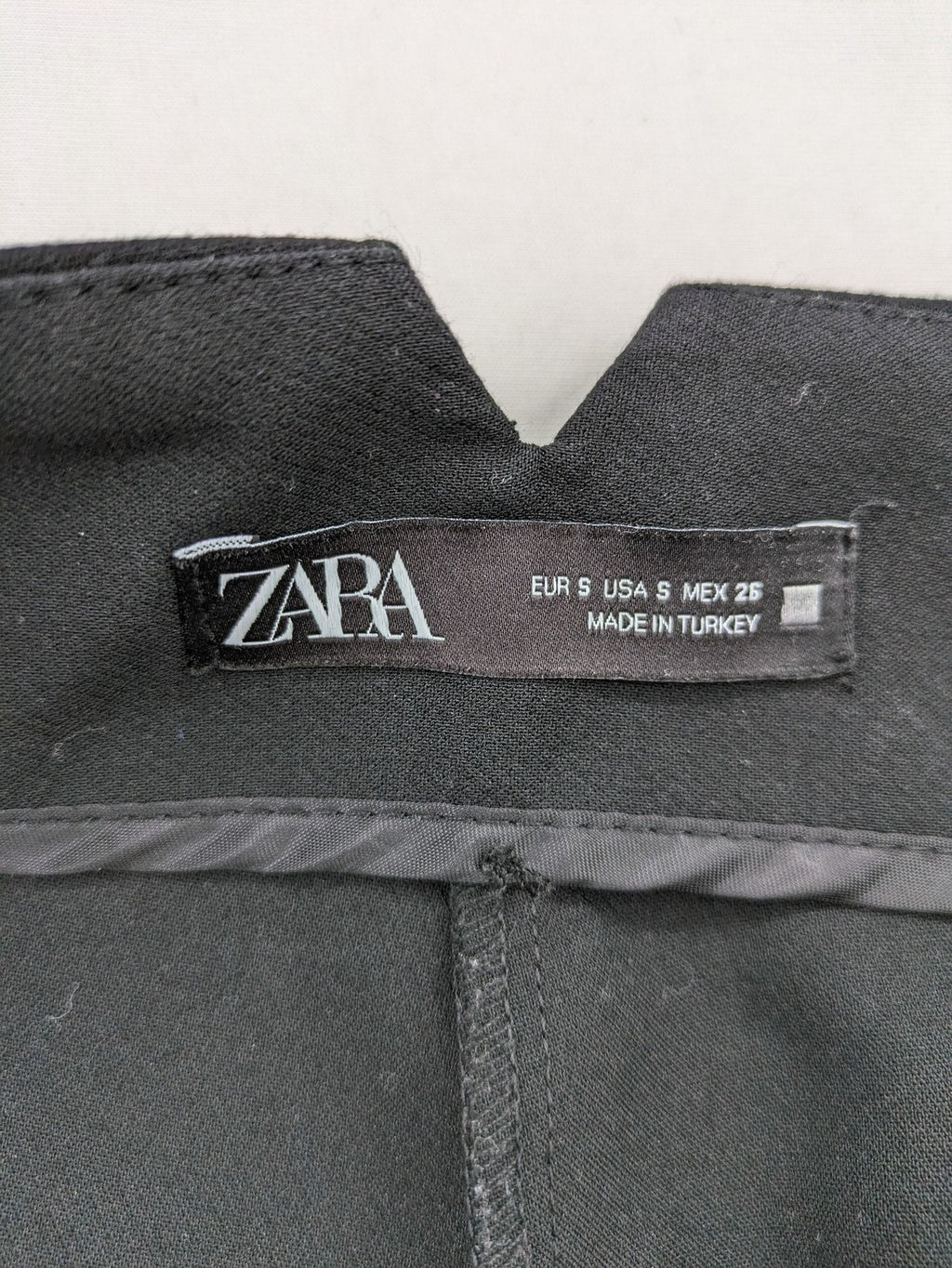 Zara black high-waist pants with concealed zipper, hook and button closure, elegant design.