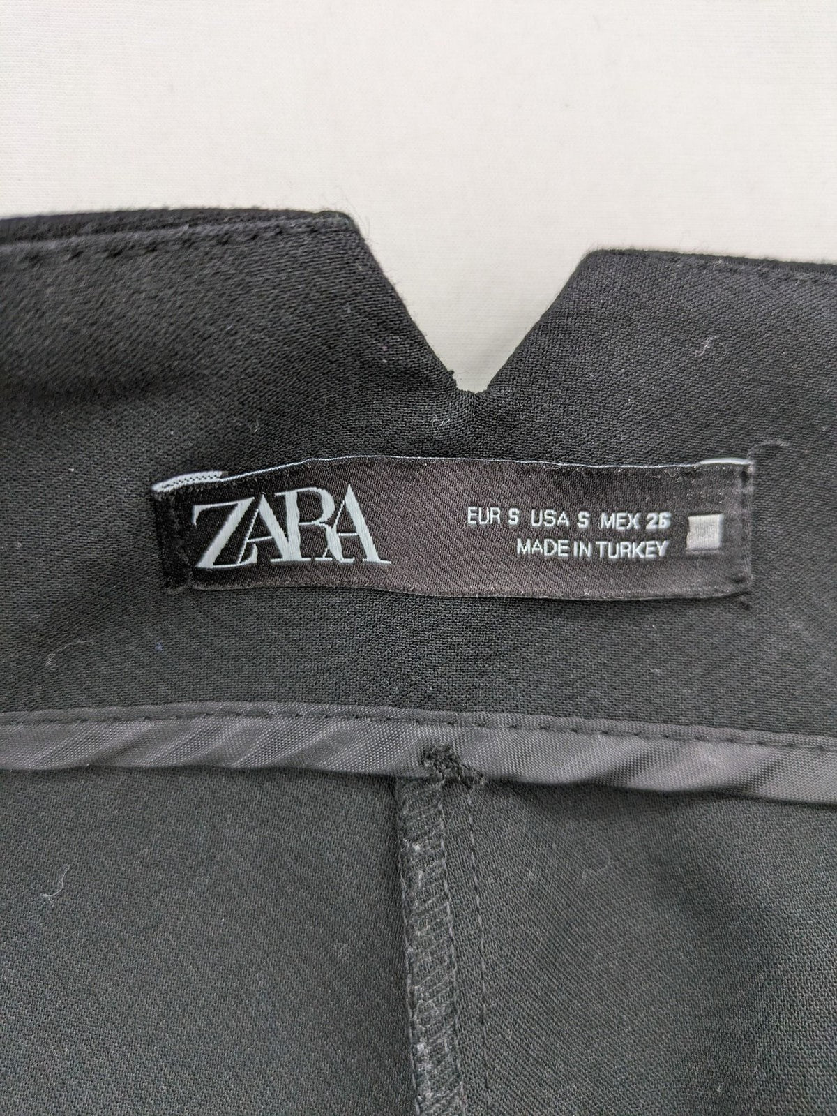 Zara black high-waist pants with concealed zipper, hook and button closure, elegant design.