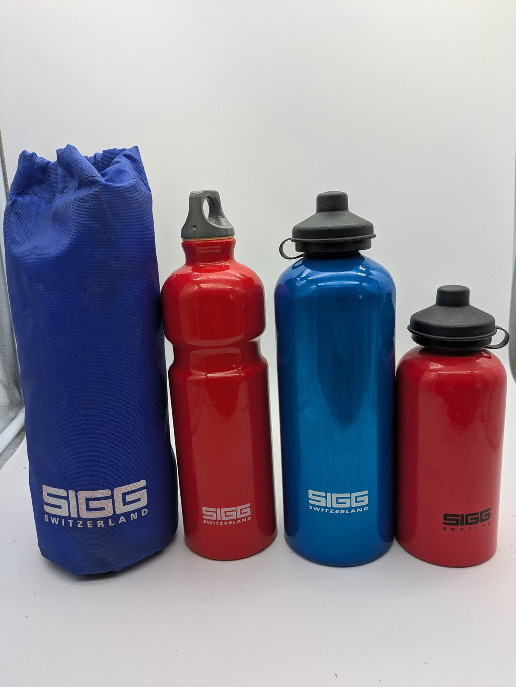 SIGG blue thermos set with red accents, durable aluminum, stylish outdoor design.