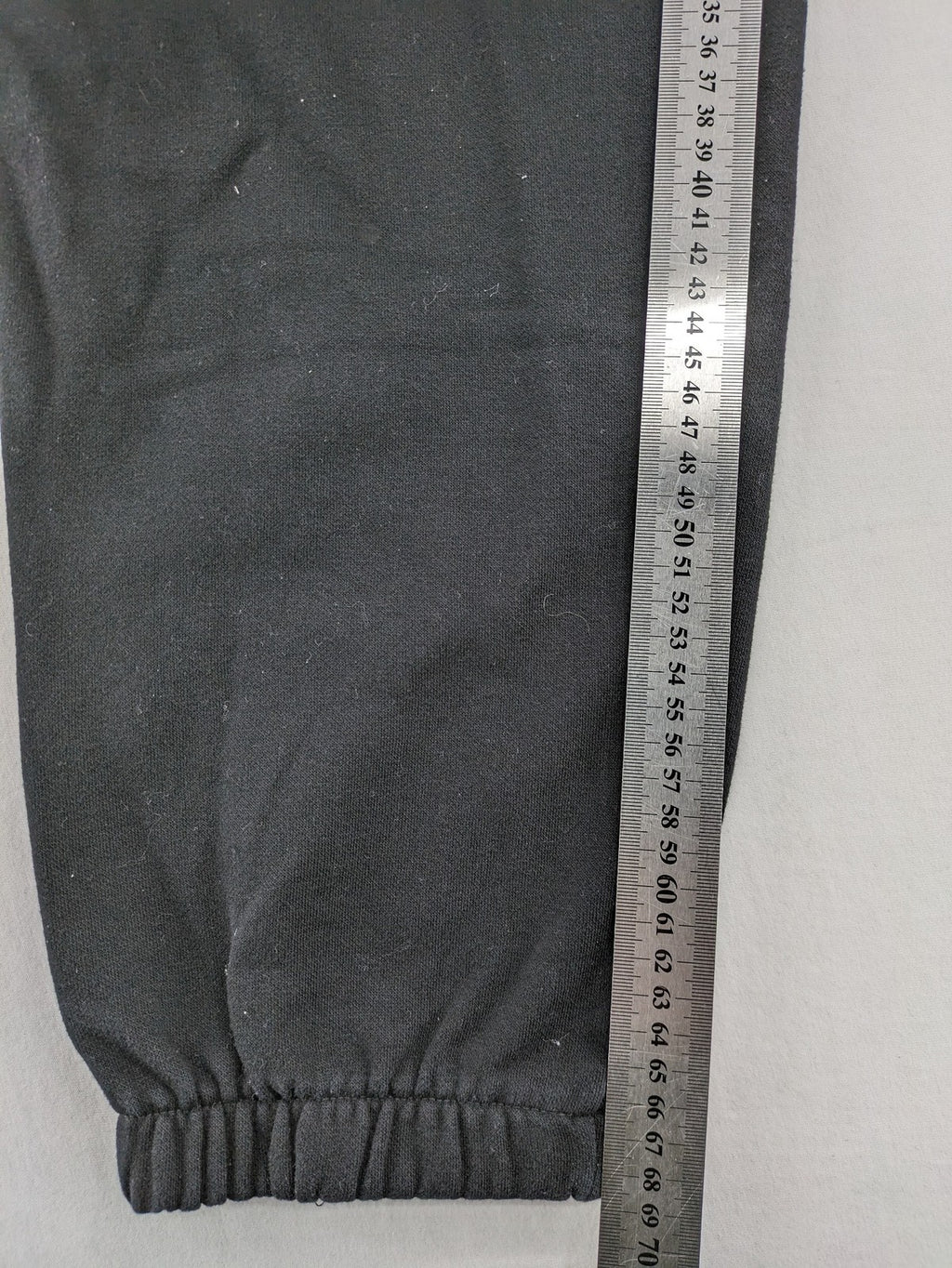 H&M black sweatpants with adjustable drawstring, elastic cuffs, and side pockets.