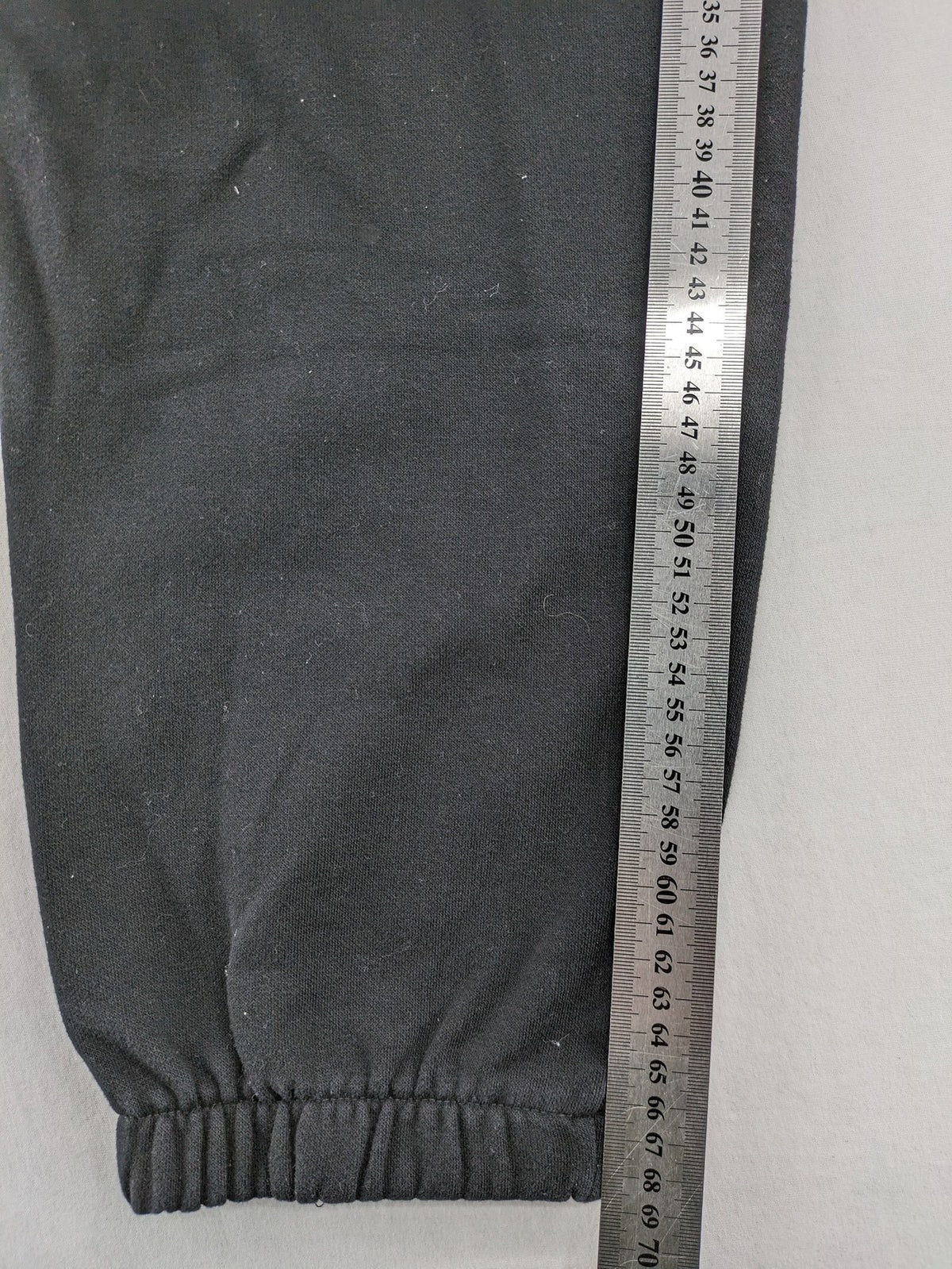 H&M black sweatpants with adjustable drawstring, elastic cuffs, and side pockets.