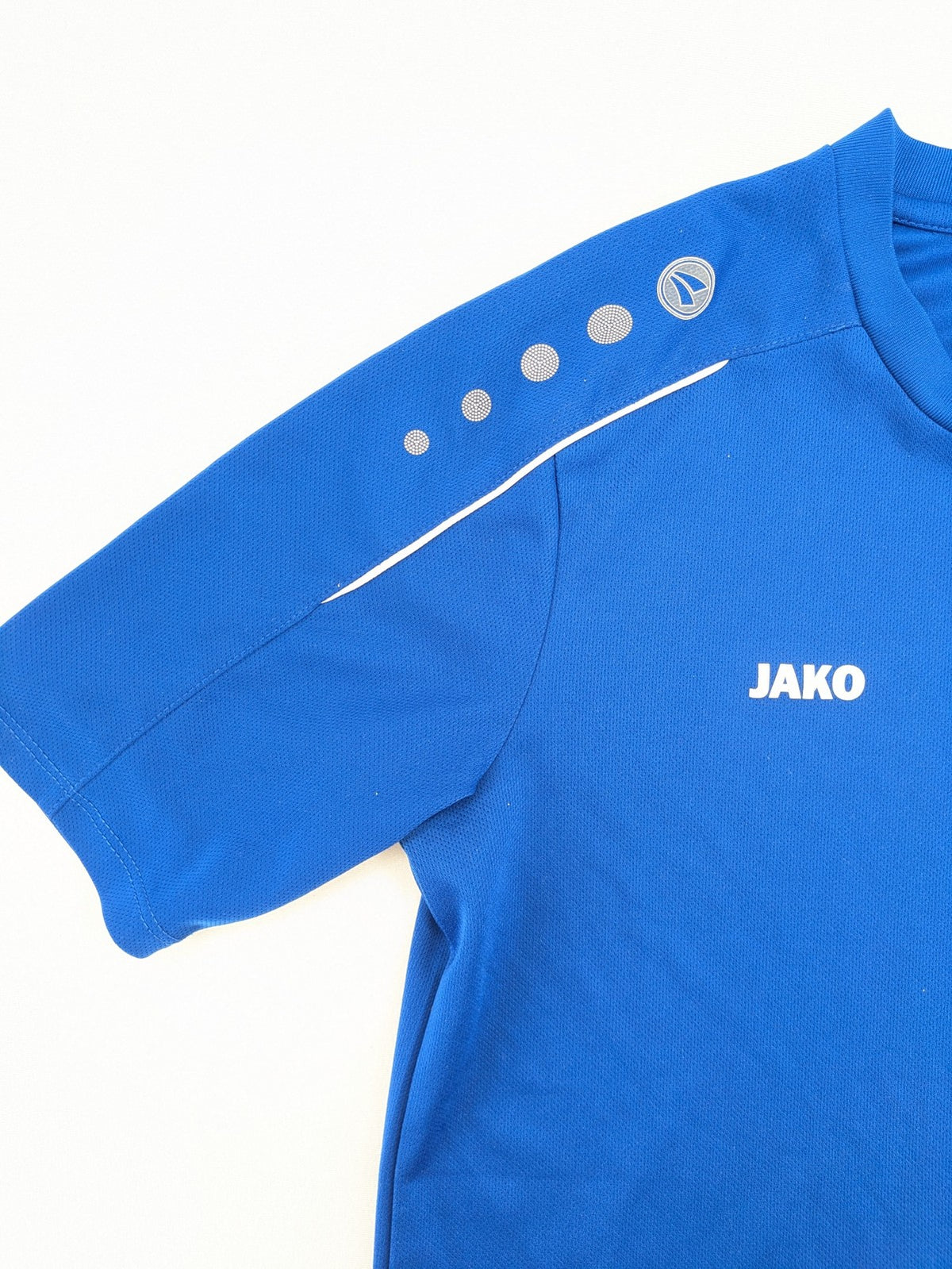 Jako blue short-sleeve training shirt with logo details and breathable polyester material.
