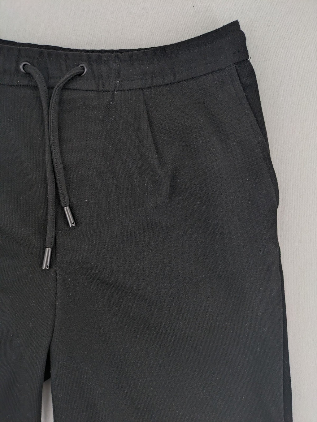 Zara black shorts with elastic drawstring, pleats, and rolled hem detail.