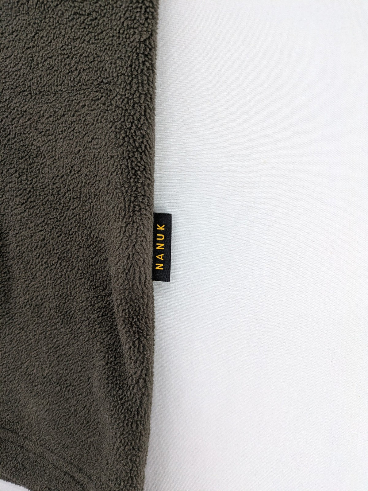 Jack Wolfskin khaki turtle neck jumper with quarter zip and embroidered paw logo.