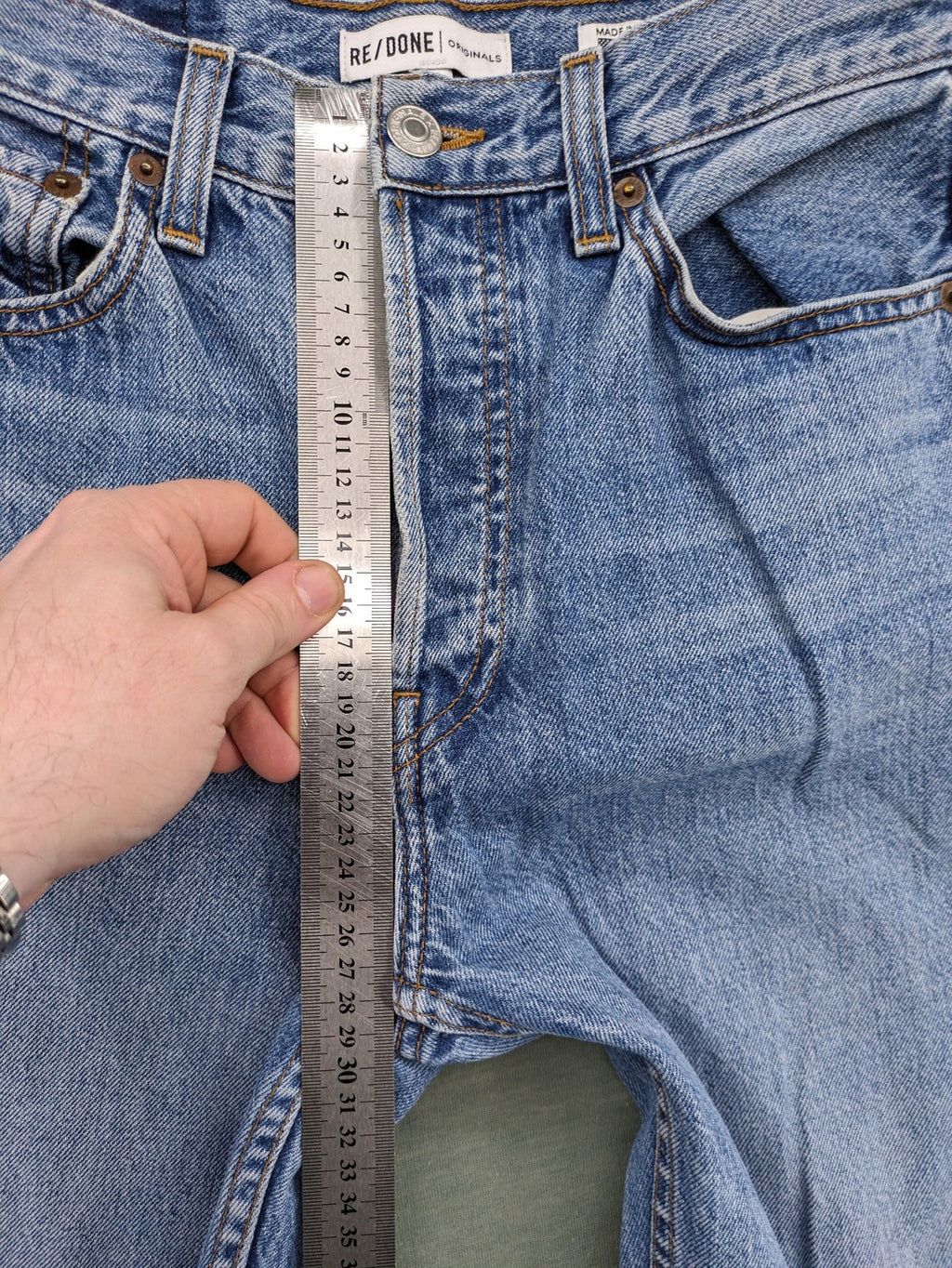 Re/Done blue straight jeans high rise with button fly and raw hem detail.