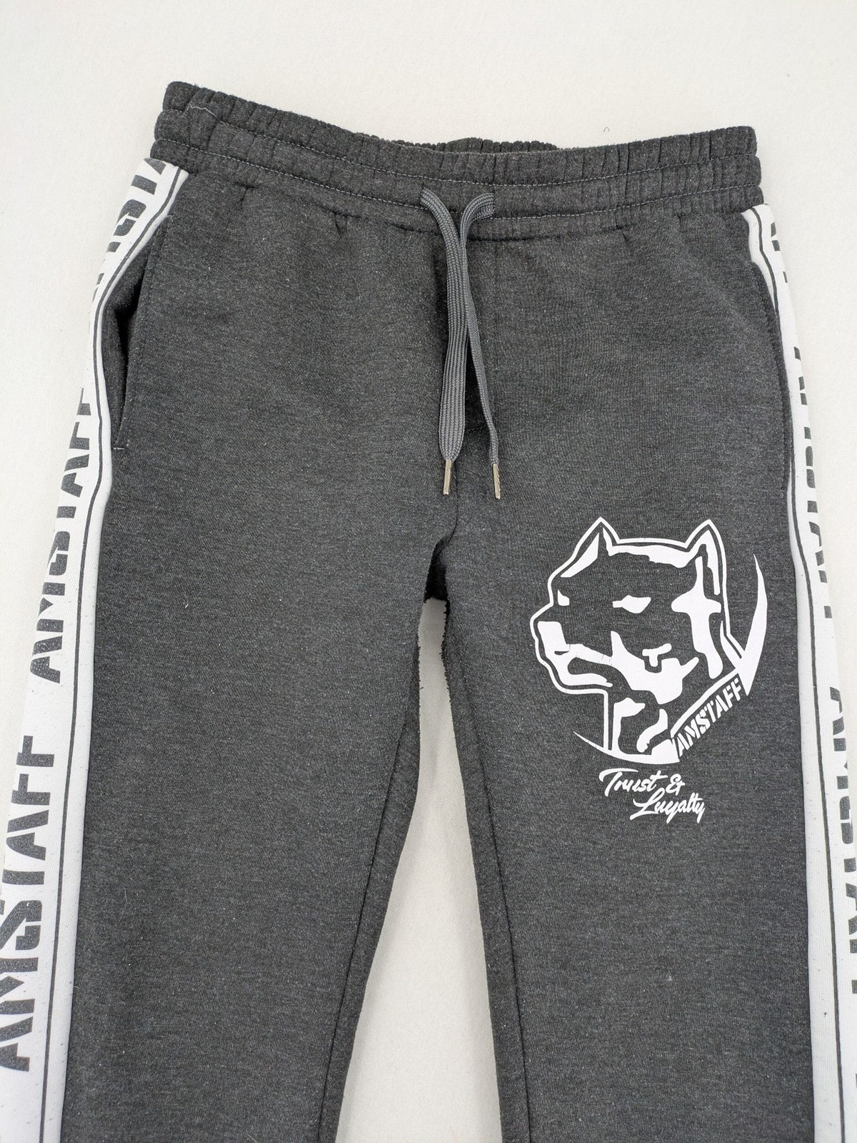 Amstaff grey sweatpants with large dog logo and "Trust & Loyalty" text.