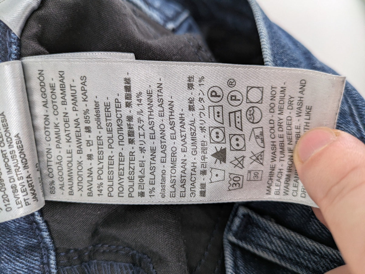 Levi's high waisted taper jeans dark blue 5-pocket design with zipper and stretch material.