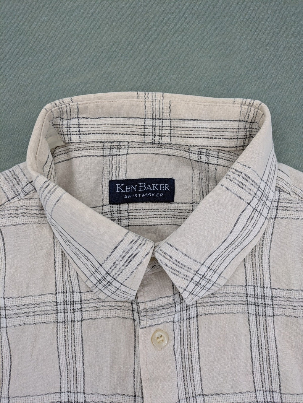 Ken Baker short-sleeve button-down shirt beige blue check pattern with single chest pocket.