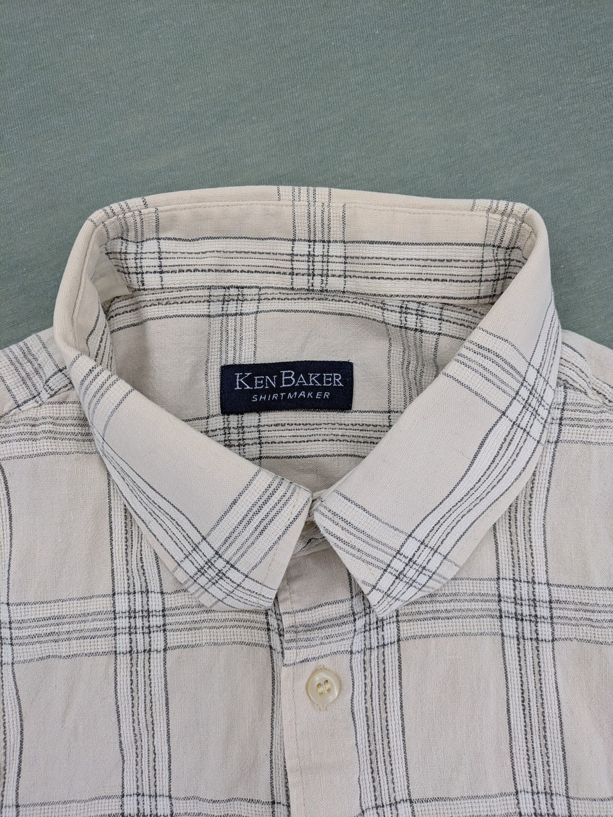 Ken Baker short-sleeve button-down shirt beige blue check pattern with single chest pocket.