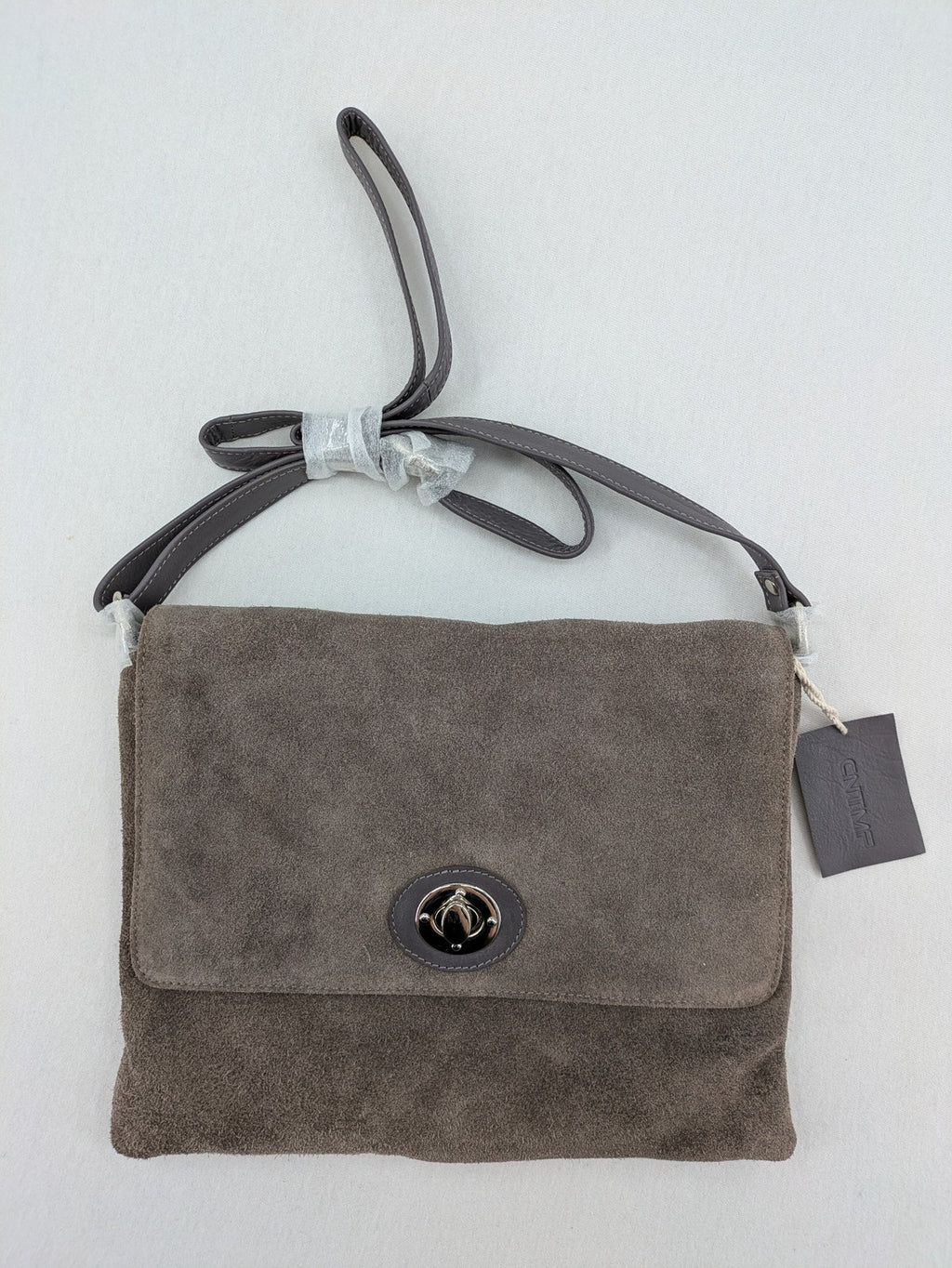 CNTMP grey suede crossbody handbag with flap and silver twist lock closure.