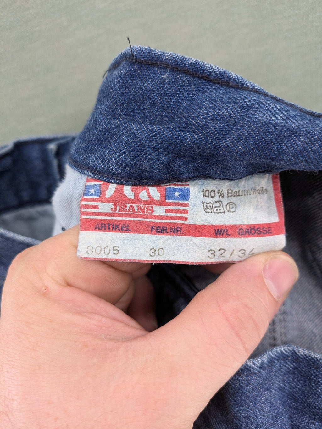 YKK blue high waist mom jeans with decorative front zipper pockets and vintage denim texture.