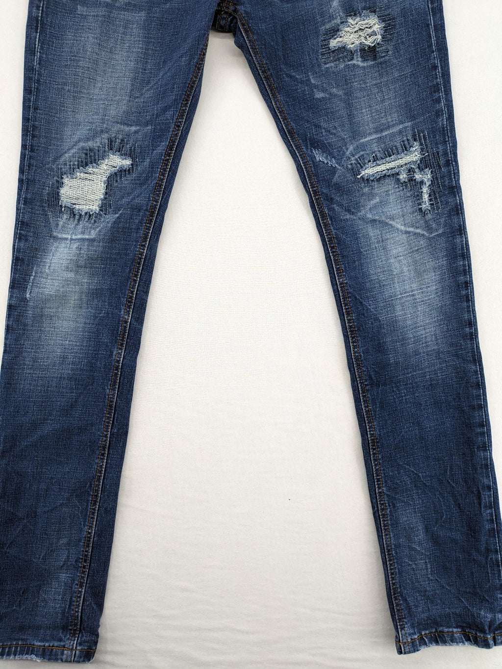 Soda blue straight jeans with distressed rips and button fly, cotton blend material.