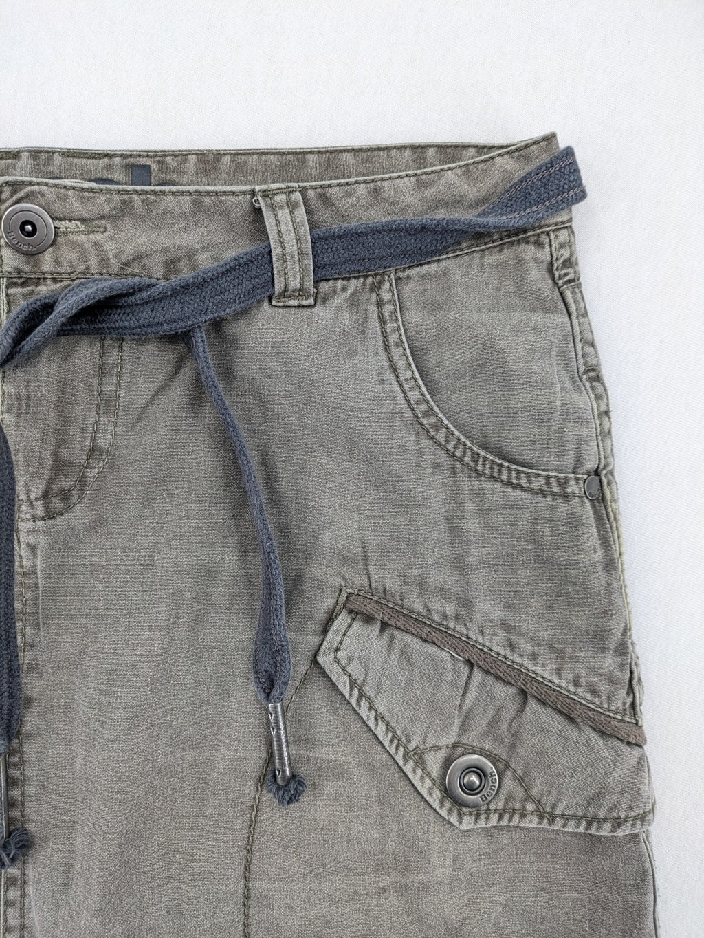 Bench khaki cargo mini skirt with belt, multiple pockets, and durable cotton material.
