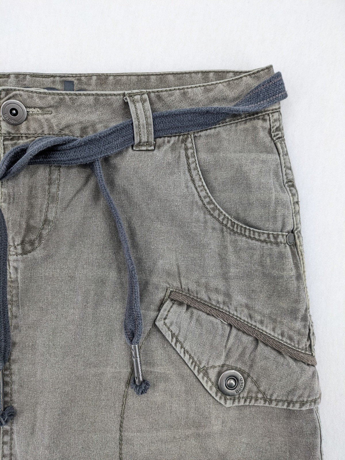 Bench khaki cargo mini skirt with belt, multiple pockets, and durable cotton material.