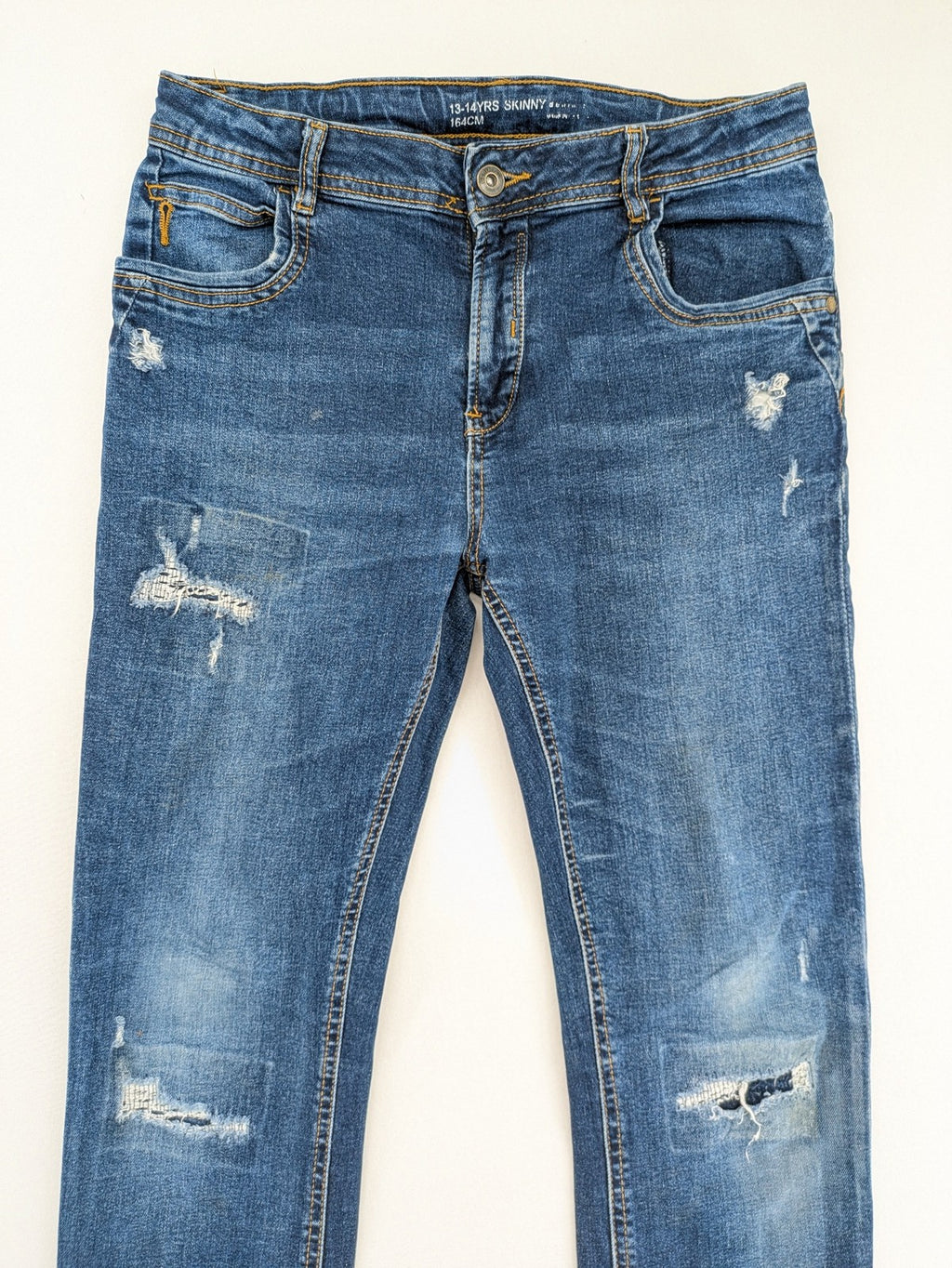Denim & Co. blue skinny jeans with distressed ripped details and adjustable waistband.