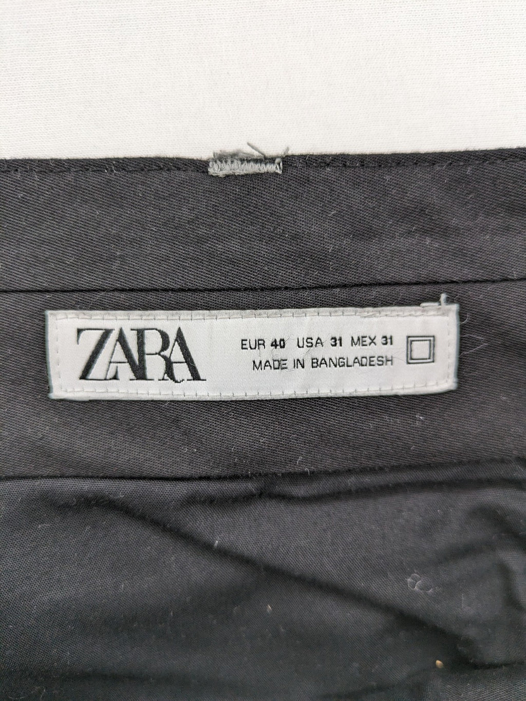 Zara pink pants with button and zipper closure, featuring side pockets and elegant design.