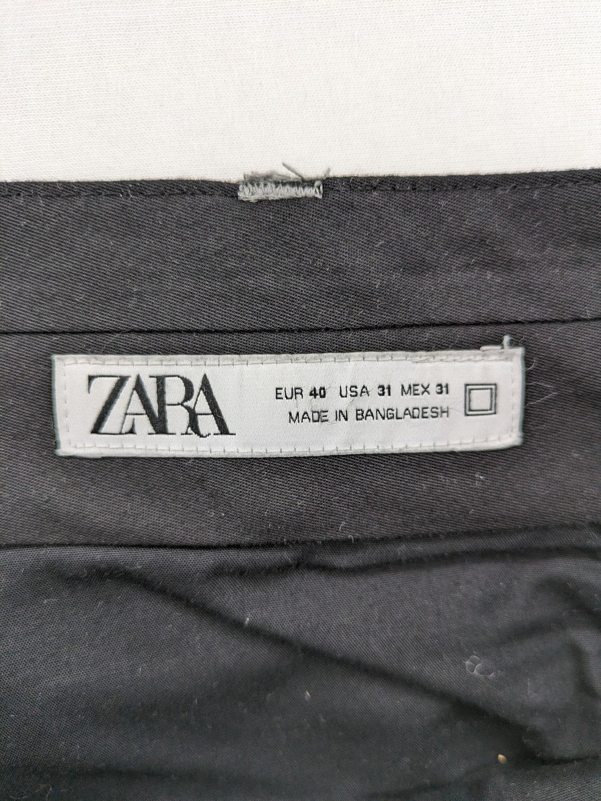 Zara pink pants with button and zipper closure, featuring side pockets and elegant design.