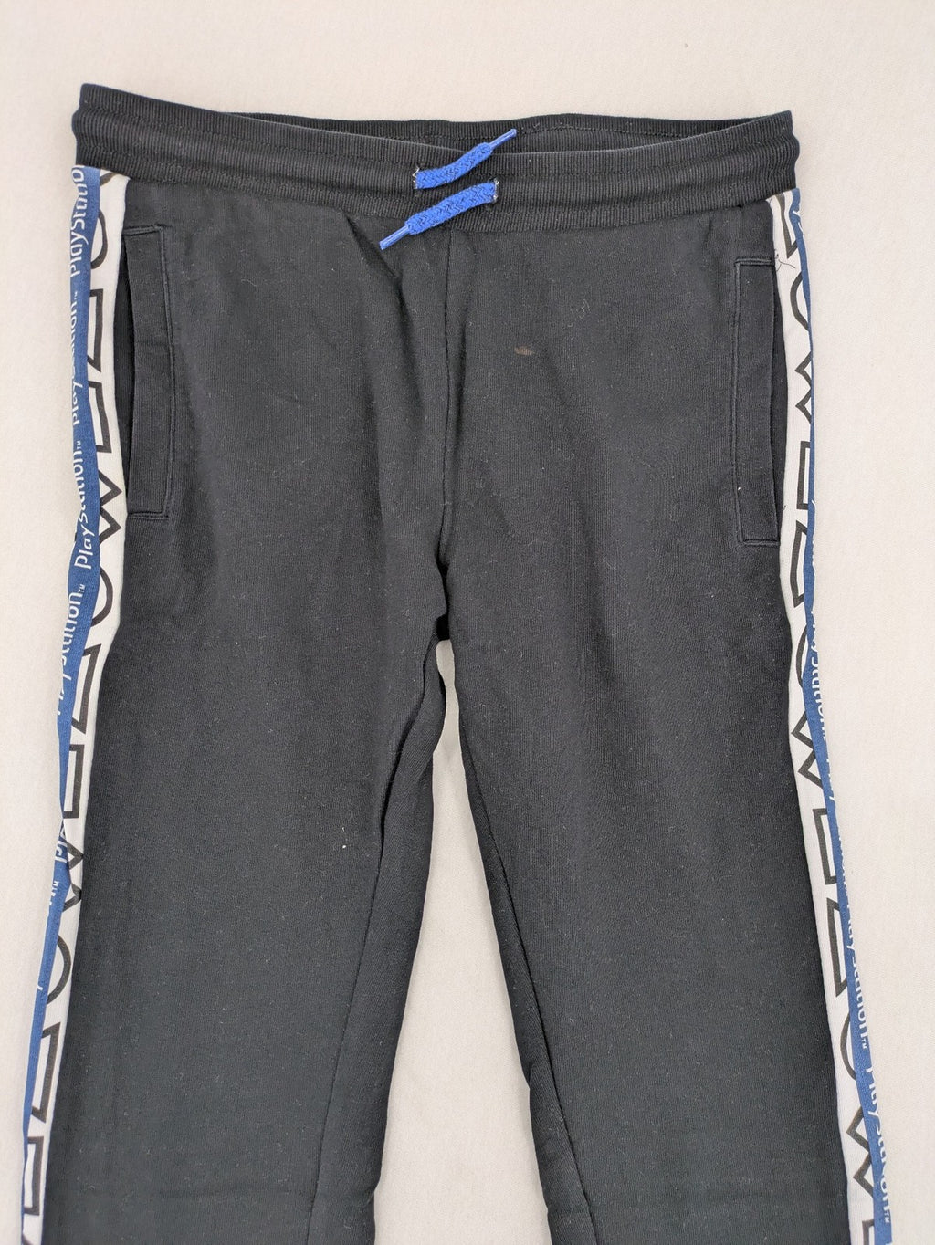 Baumwolle black pants with PlayStation logo tape, elastic waistband, cotton material.