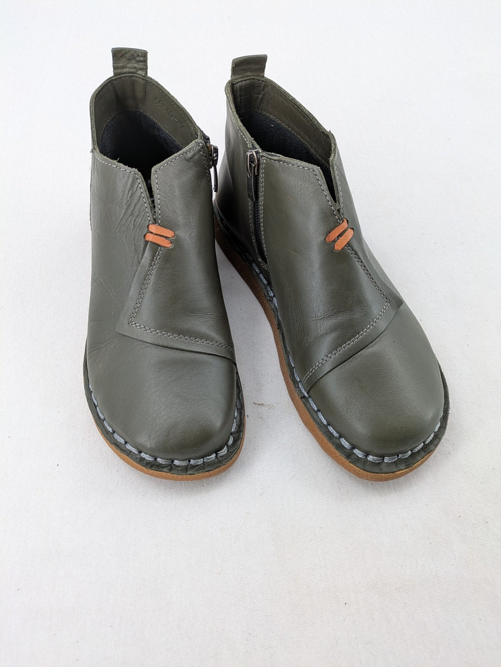 ALS green leather booties with side zipper and decorative stitching.