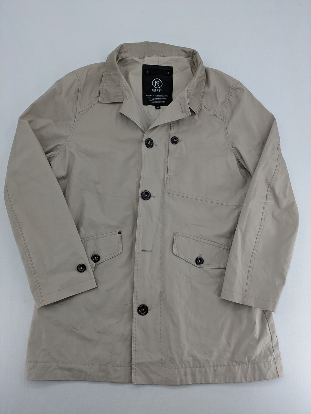ReSET beige coat with contrasting dark blue lining and classic design details.