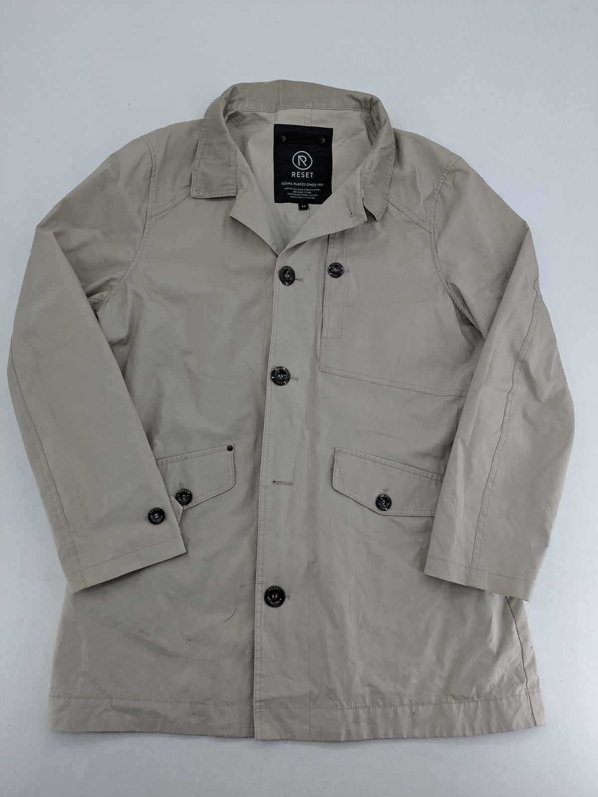 ReSET beige coat with contrasting dark blue lining and classic design details.