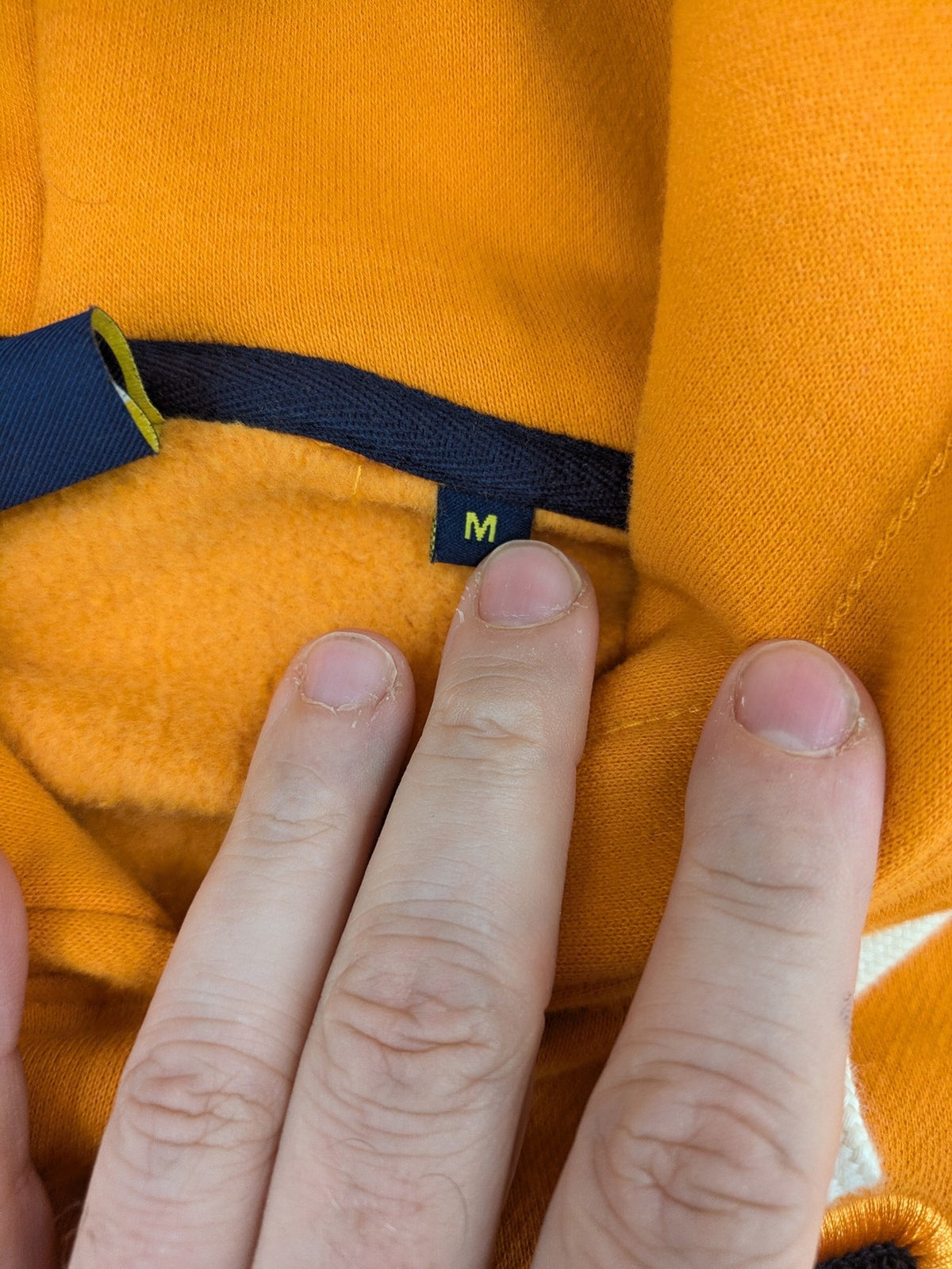 Superdry orange turtle neck jumper with textured logo patch and number 7 detail.