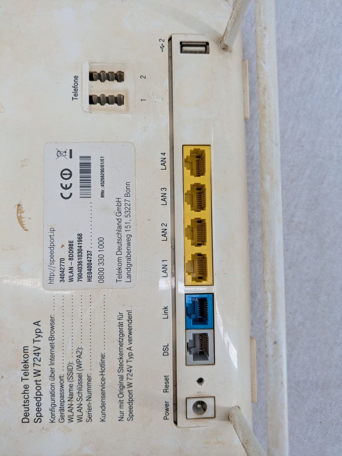 Deutsche Telekom beige wireless router with multiple LAN and VoIP ports.