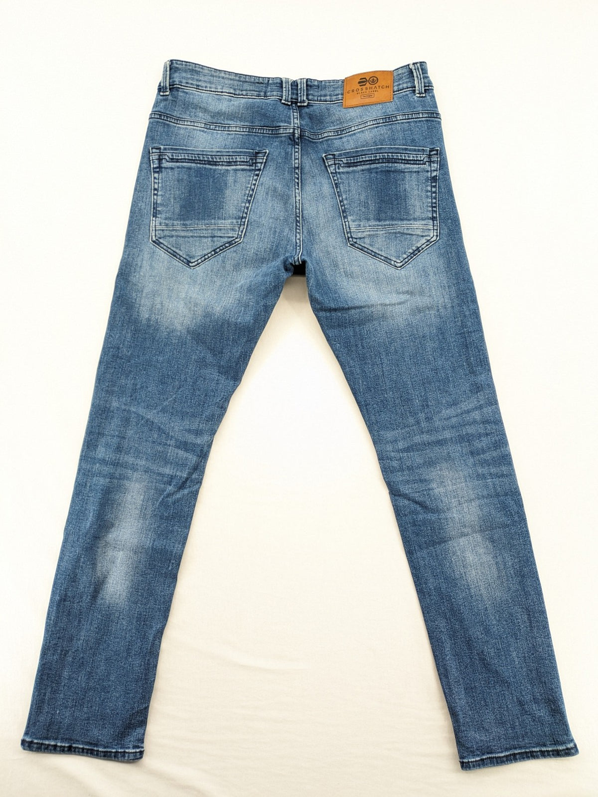 Crosshatch blue slim fit jeans with faded wash and logo patch on back pocket.