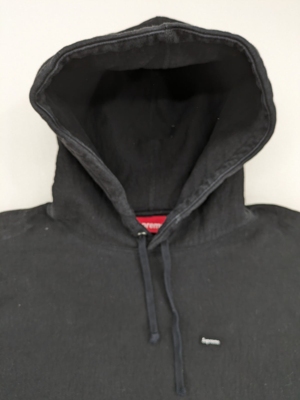 Supreme grey hoodie with embroidered small box logo, kangaroo pocket, and ribbed cuffs.