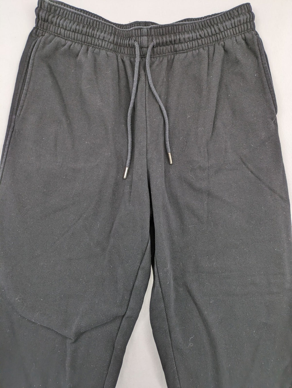 H&M black sweatpants with adjustable drawstring, elastic cuffs, and side pockets.