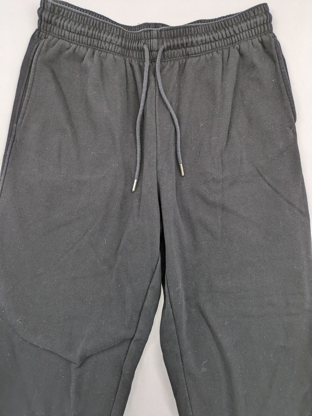 H&M black sweatpants with adjustable drawstring, elastic cuffs, and side pockets.