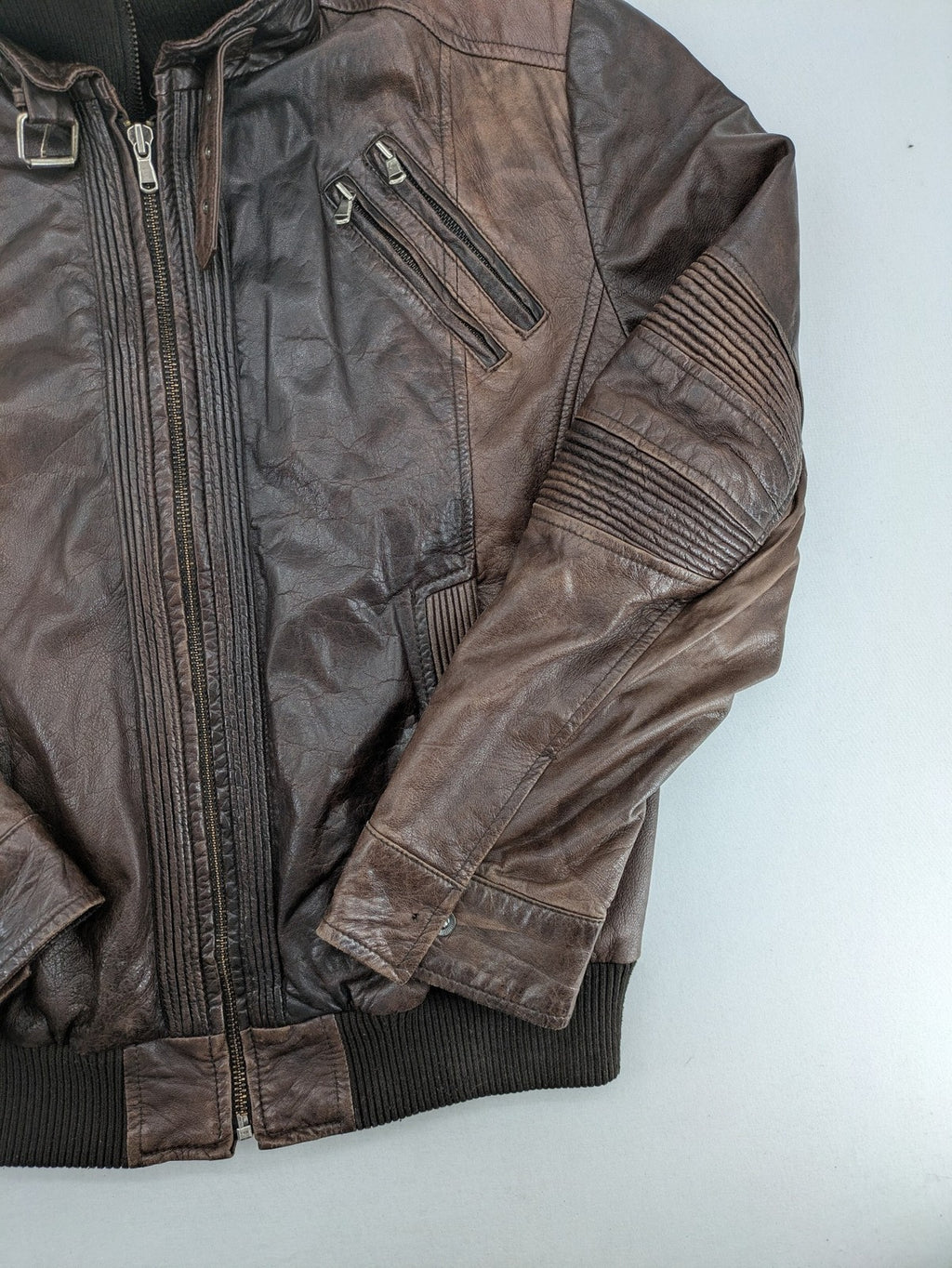 H&M green leather bomber jacket with ribbed collar and moto-style padding.
