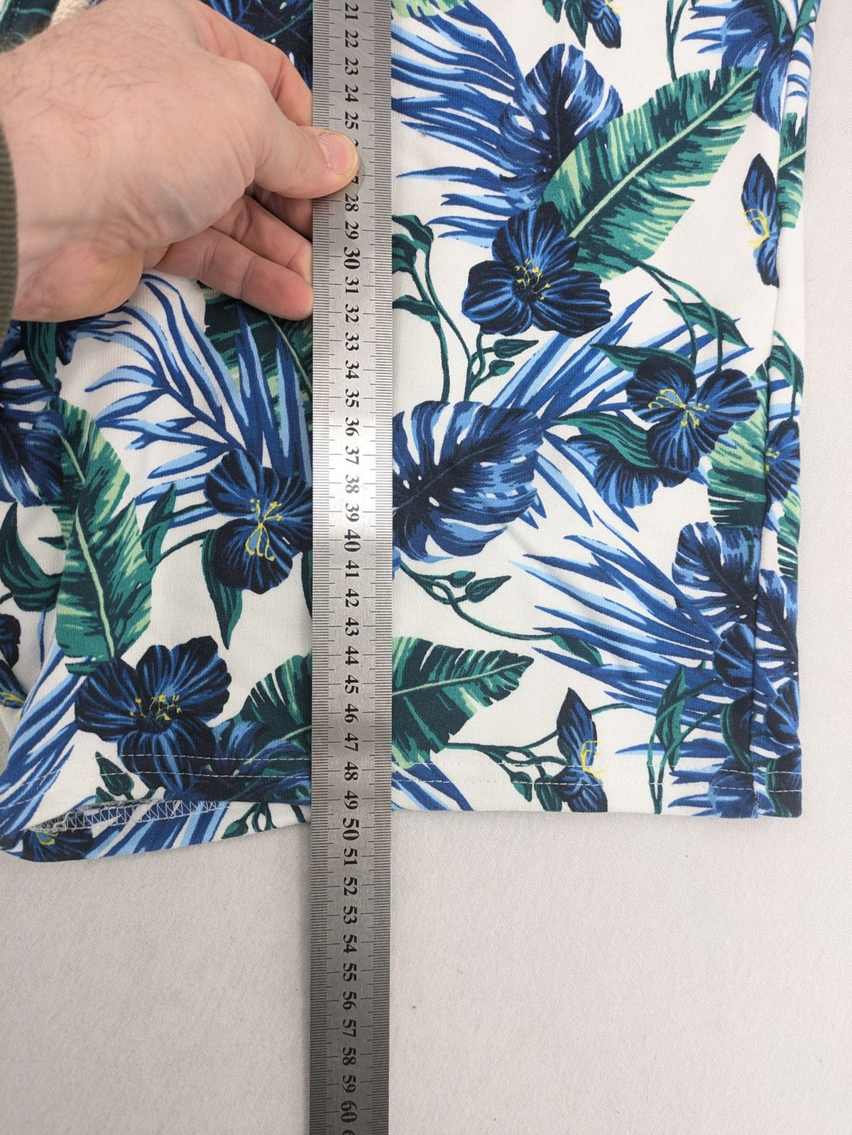 Nils Sundström blue and green tropical floral shorts with white background and elastic waistband.