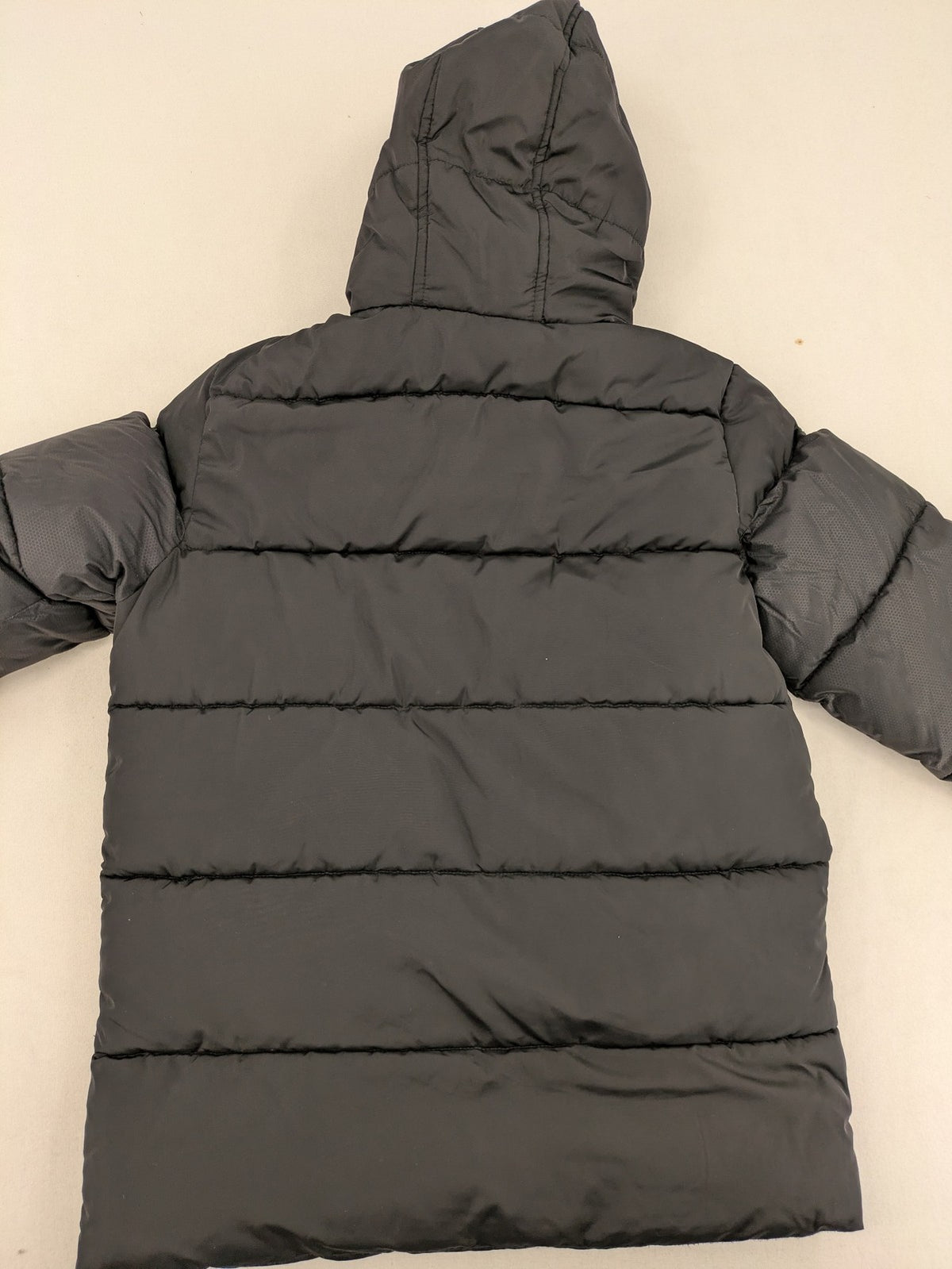 C&A black puffer jacket with NYC83 graphic, hood, and multiple pockets.