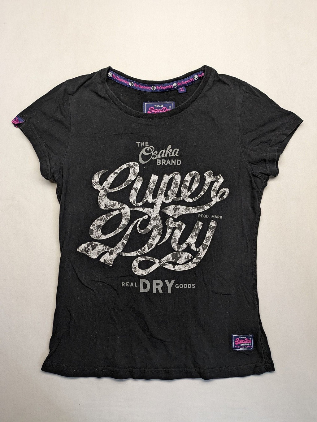 Superdry black t-shirt with large Osaka Brand logo and subtle floral pattern.