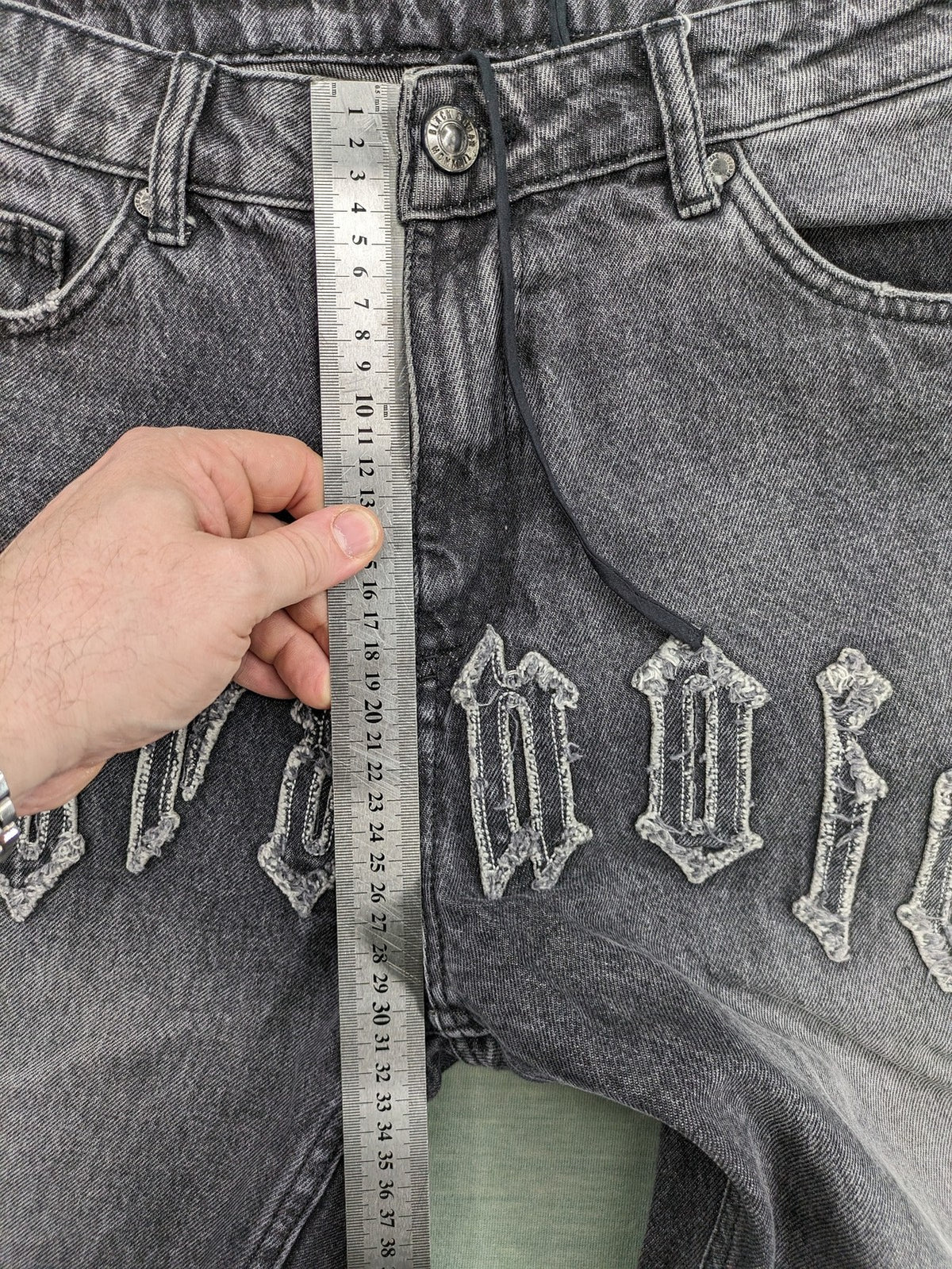 Black Squad black straight jeans with Gothic "Paranoid" lettering and faded finish.