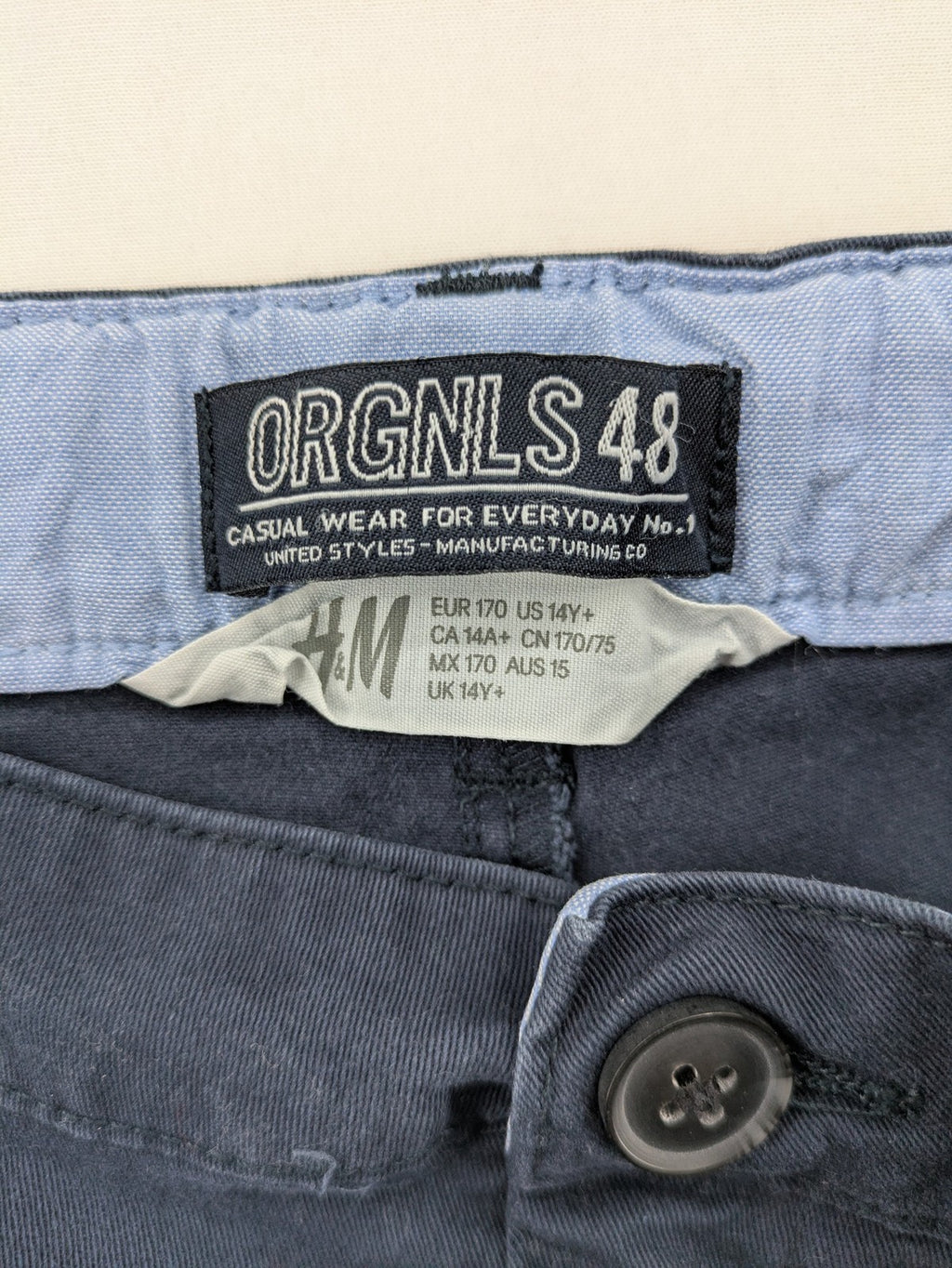 H&M navy chino pants with stretch, classic design, soft cotton blend material.