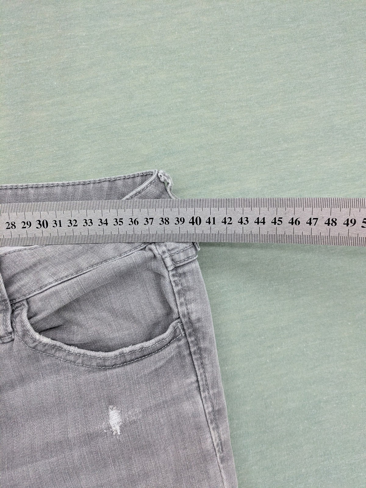 H&M grey super skinny jeans with distressed knee details and low waist fit.