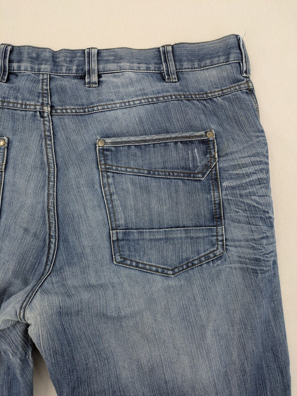 Premium Denim blue straight leg jeans with biker knee inserts and five-pocket design.