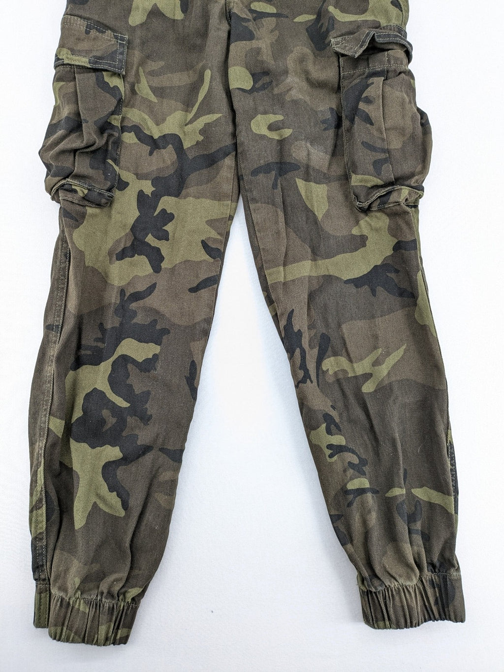 Rainbow camouflage cargo pants in green-brown with jogger silhouette and multiple pockets.