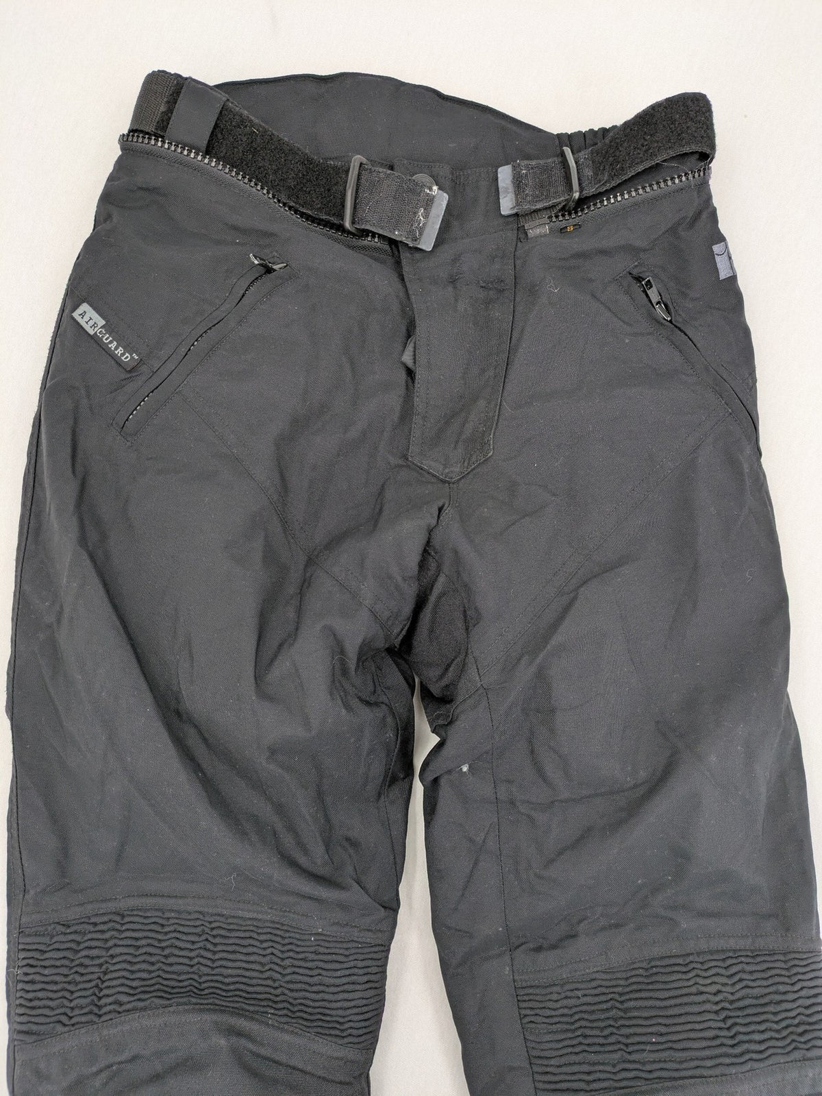iXS black chaps with grey accents, waterproof textile, adjustable belt, reinforced knees.