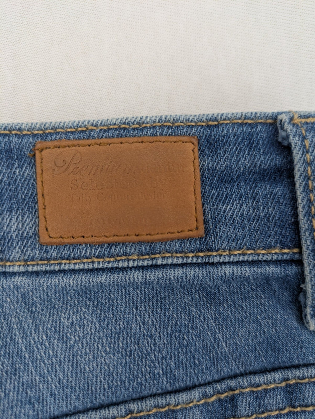 Tally Weijl blue bootcut jeans with distressed knees and raw hem detail.