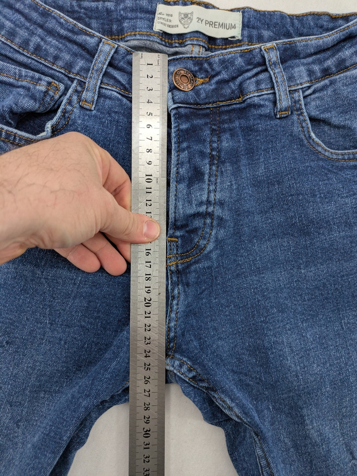 2Y Premium blue skinny jeans with distressed details and classic button fly.