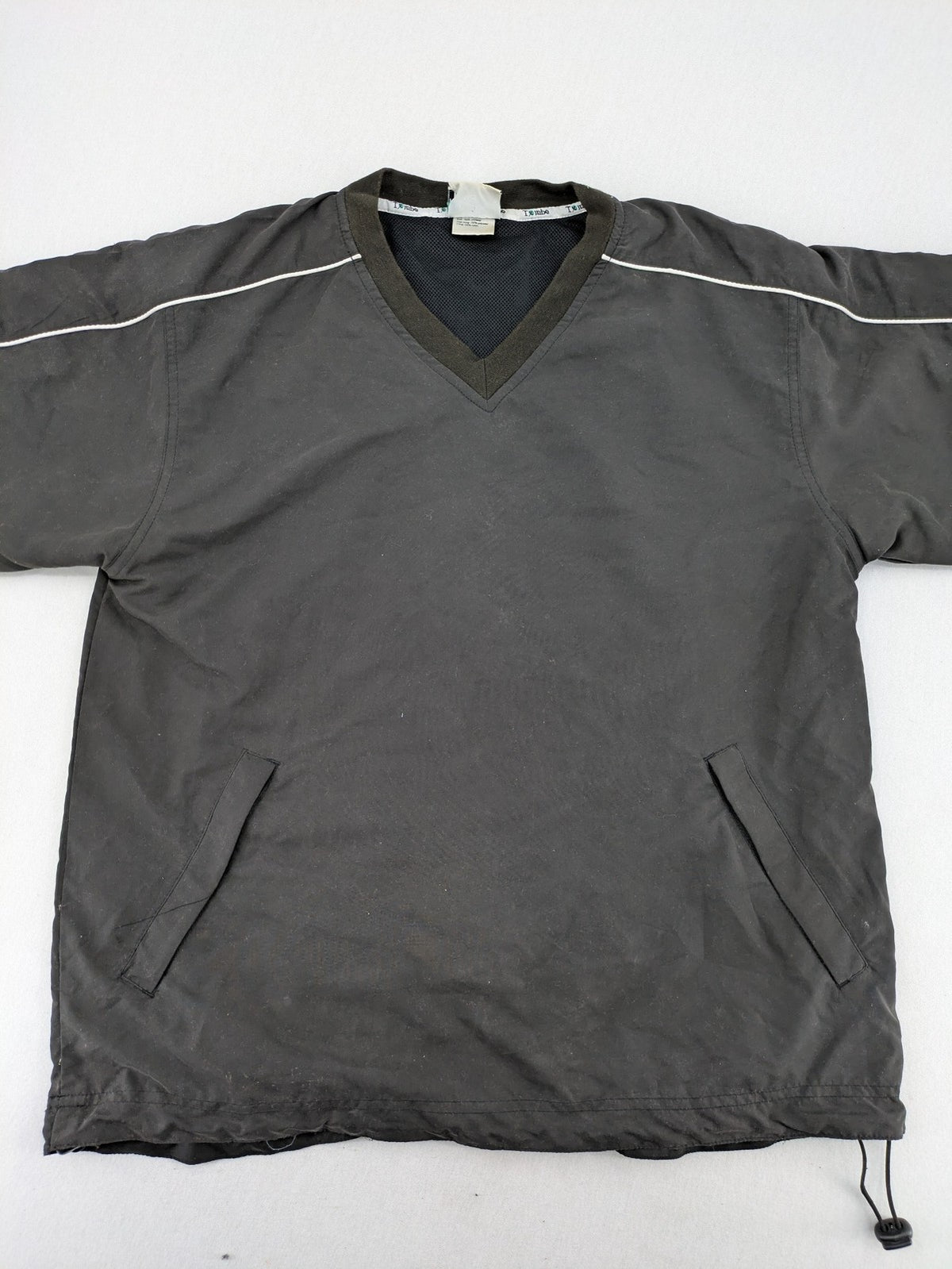 Tombo green windbreaker jacket with white piping, V-neck, and zippered pockets.