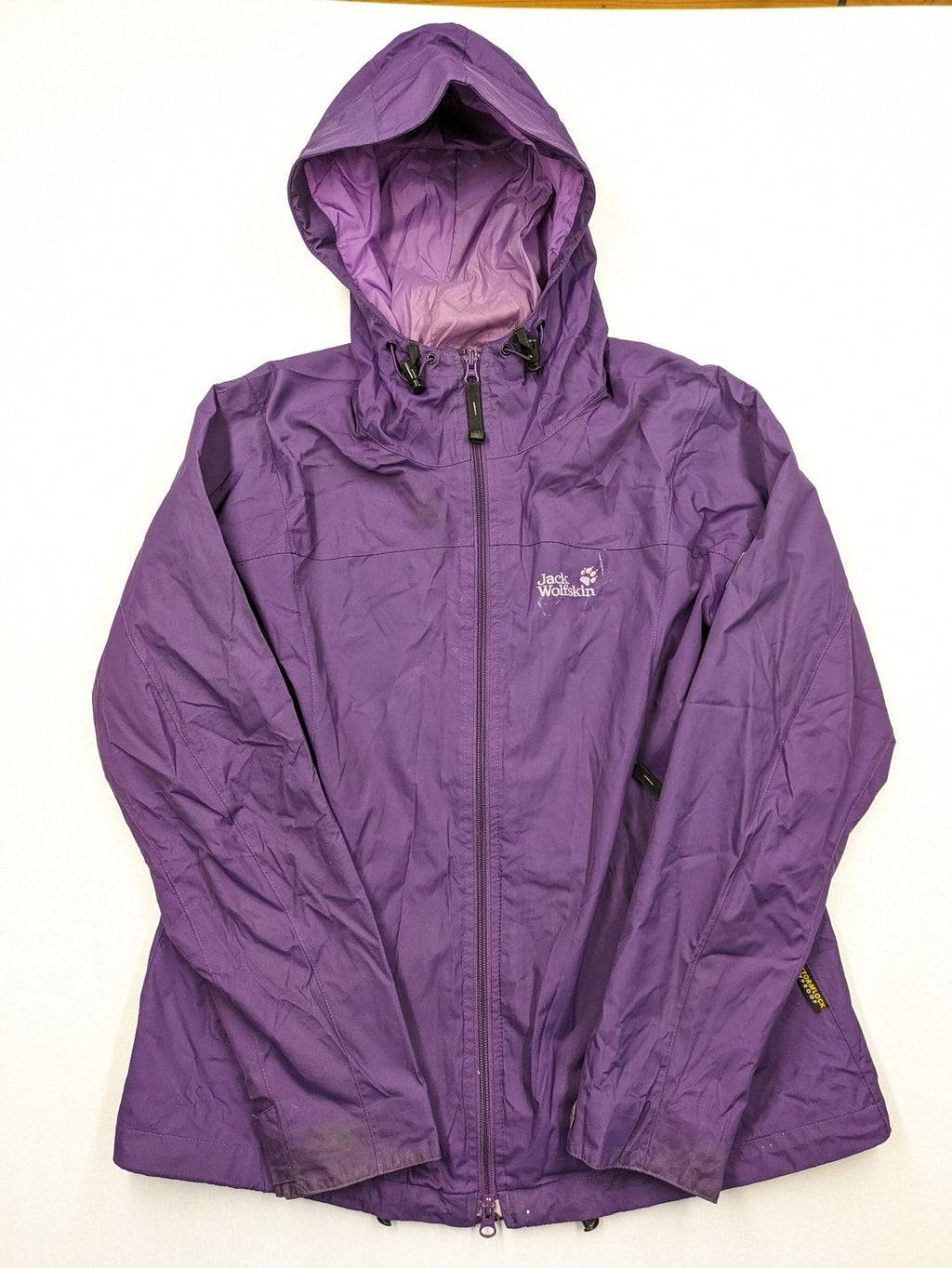Jack Wolfskin purple outdoor jacket with adjustable hood and full zip, lightweight Stormlock material.