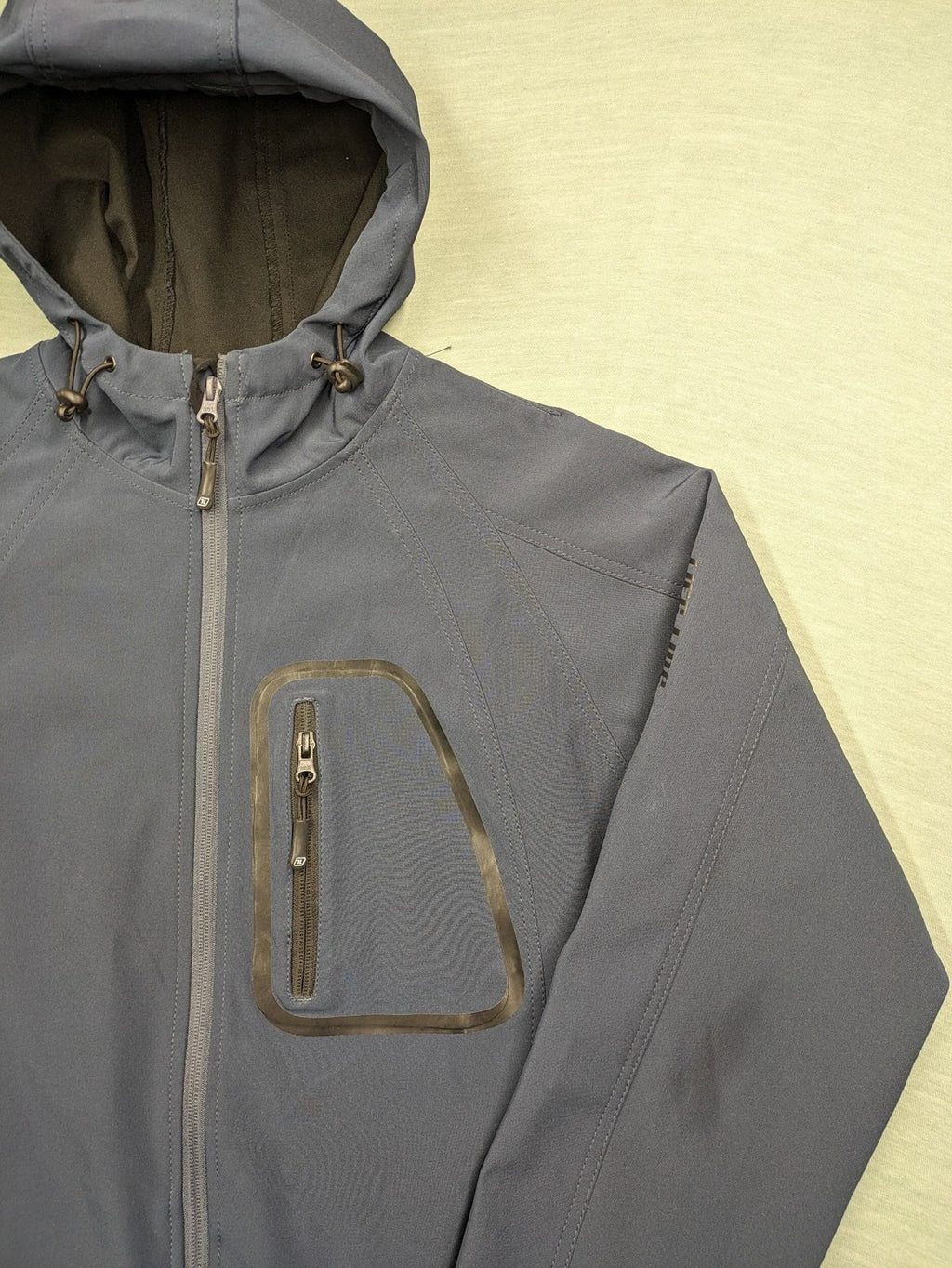 Life Line grey softshell jacket with adjustable hood and durable wind-resistant material.