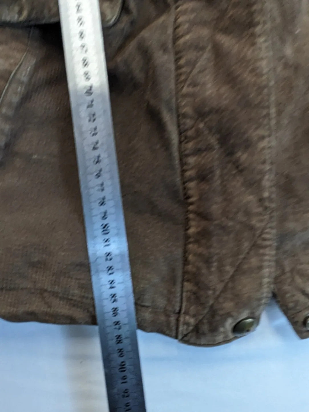 Vintage brown leather jacket with graphic lining, zip closure, and button placket.